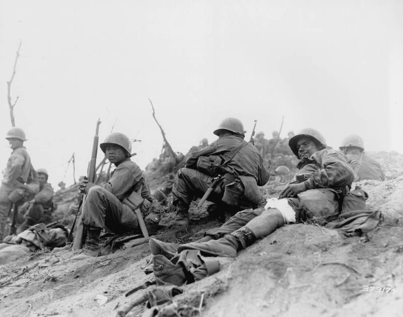 Cpl. Sam Ayala of Niles, Calif., Co. L, 7th RCT, U.S. 3rd Infantry Division, waits for medical evacuation from Hill 717, Cpl. Ayala was wounded while engaged in a bitter grenade battle with deeply entrenched Chinese Communism. 3 July 1951. Korea. Photo from U.S. Army Signal Corps archive. Photo #8A/FEC-51-23541 (Brigham).” Image from U.S. Army.
