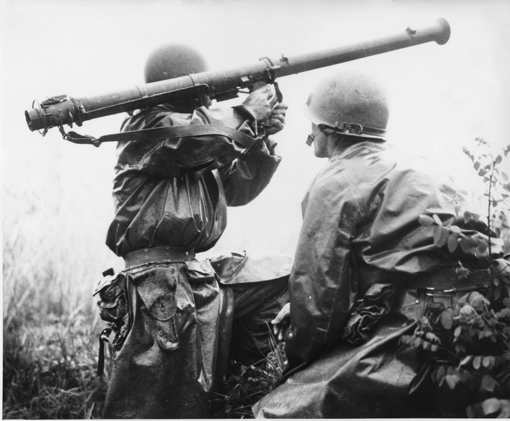 A team mans a Bazooka at the Battle of Osan. Members of the 24th Infantry Division, first United States ground units to reach the front, go into action against North Korean forces at the village of Sojong-Ni, near Osan. At right is Private First Class Kenneth Shadrick, who was killed by enemy fire a few moments after this photo was made, thus becoming the first United States soldier to die in the Korean campaign.” Photo by Charles Turnbull. Image from Wikimedia Commons.